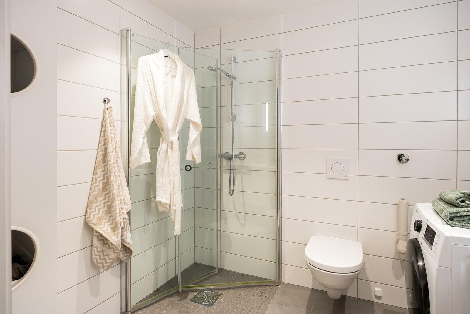 Smakfullt baderom med flislagte overflater og gulvvarme. Galleribilde