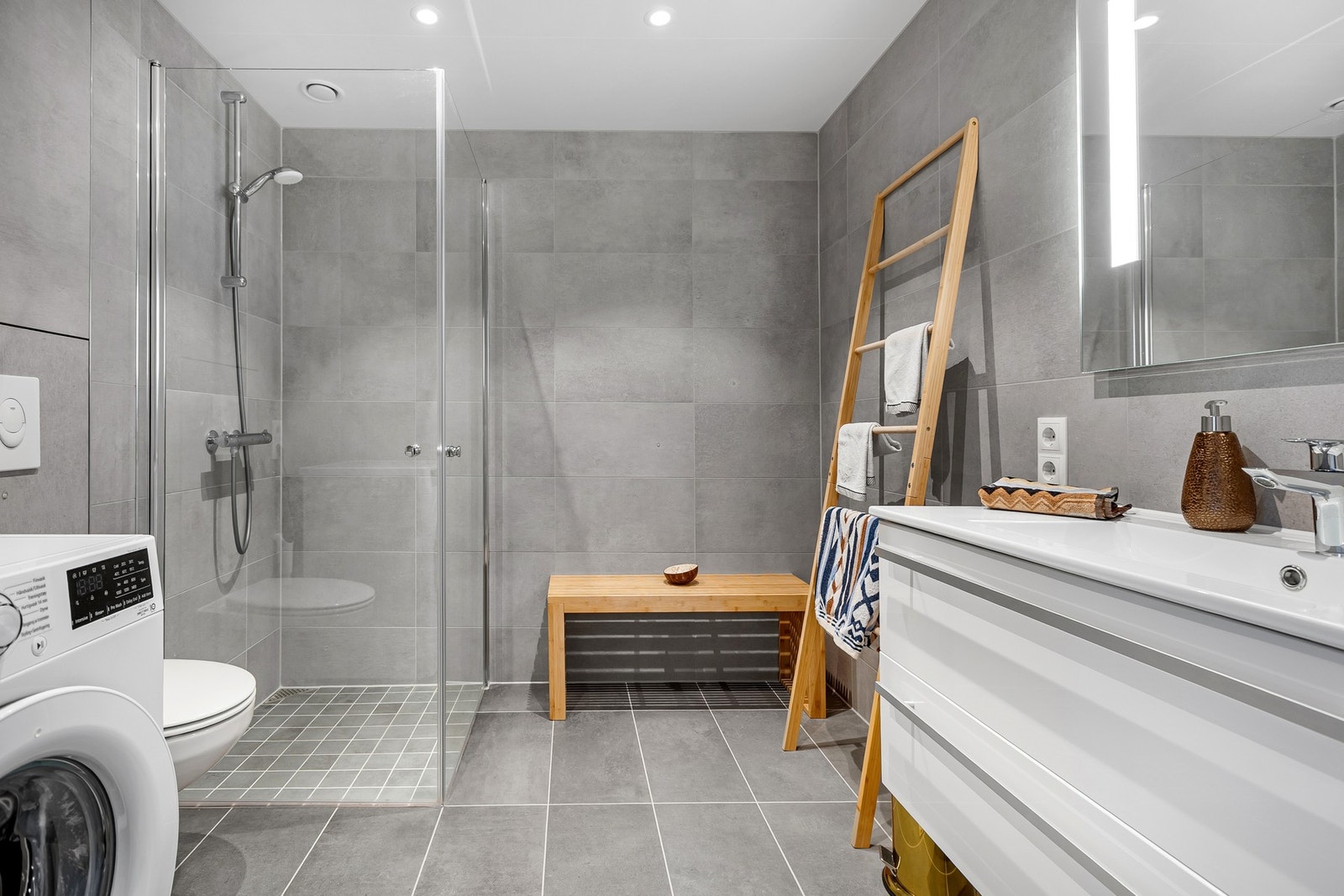 Moderne bad med flislagte overflater og downlights. Galleribilde