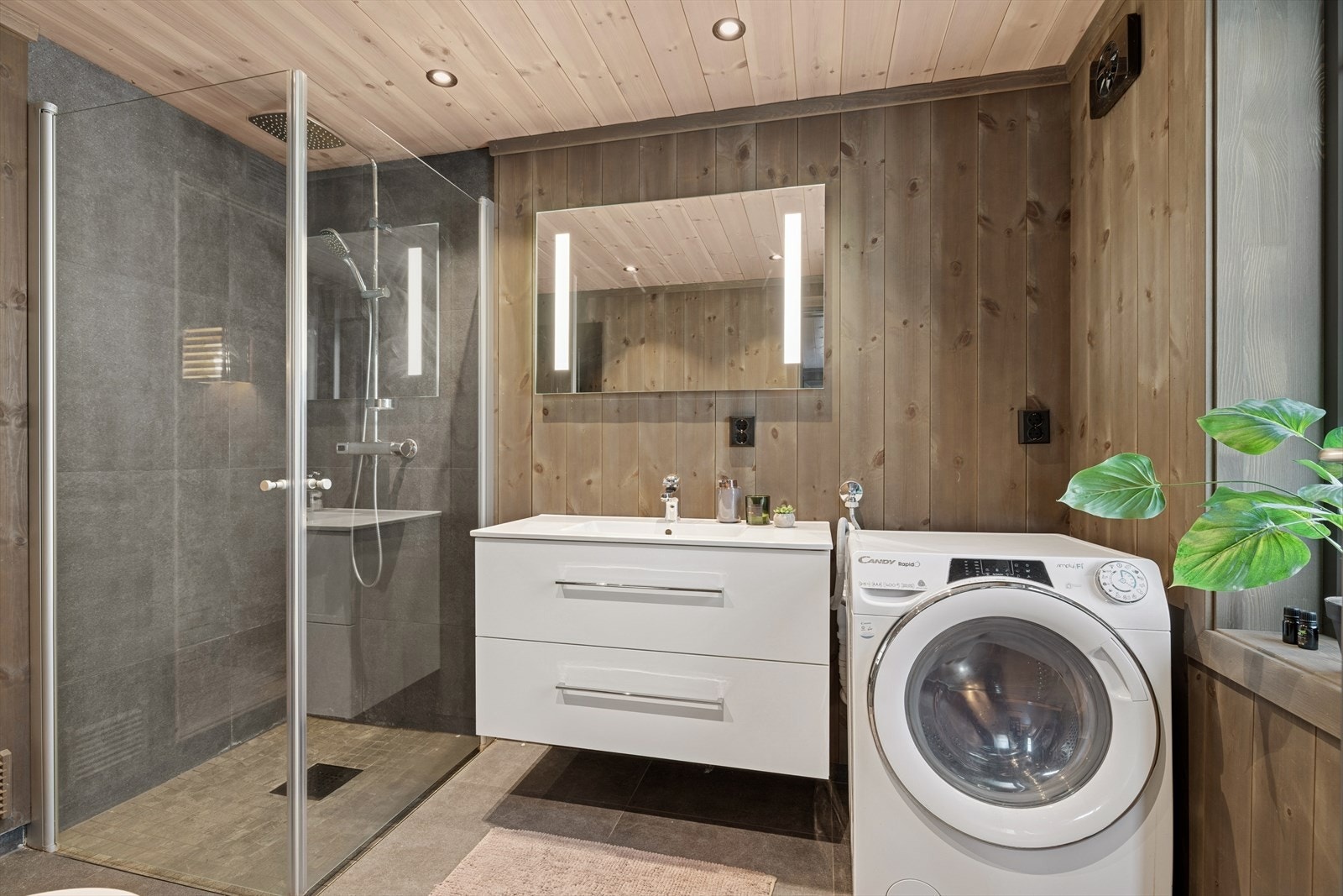 Badet inneholder servant med underskap, dusjhjørne og toalett, samt opplegg for vaskemaskin Galleribilde