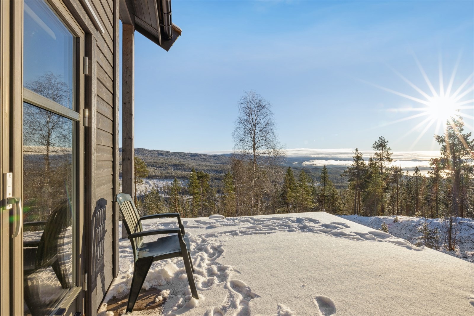 Utgang fra stuen til terrasseplatting med god plass til utemøbler Galleribilde
