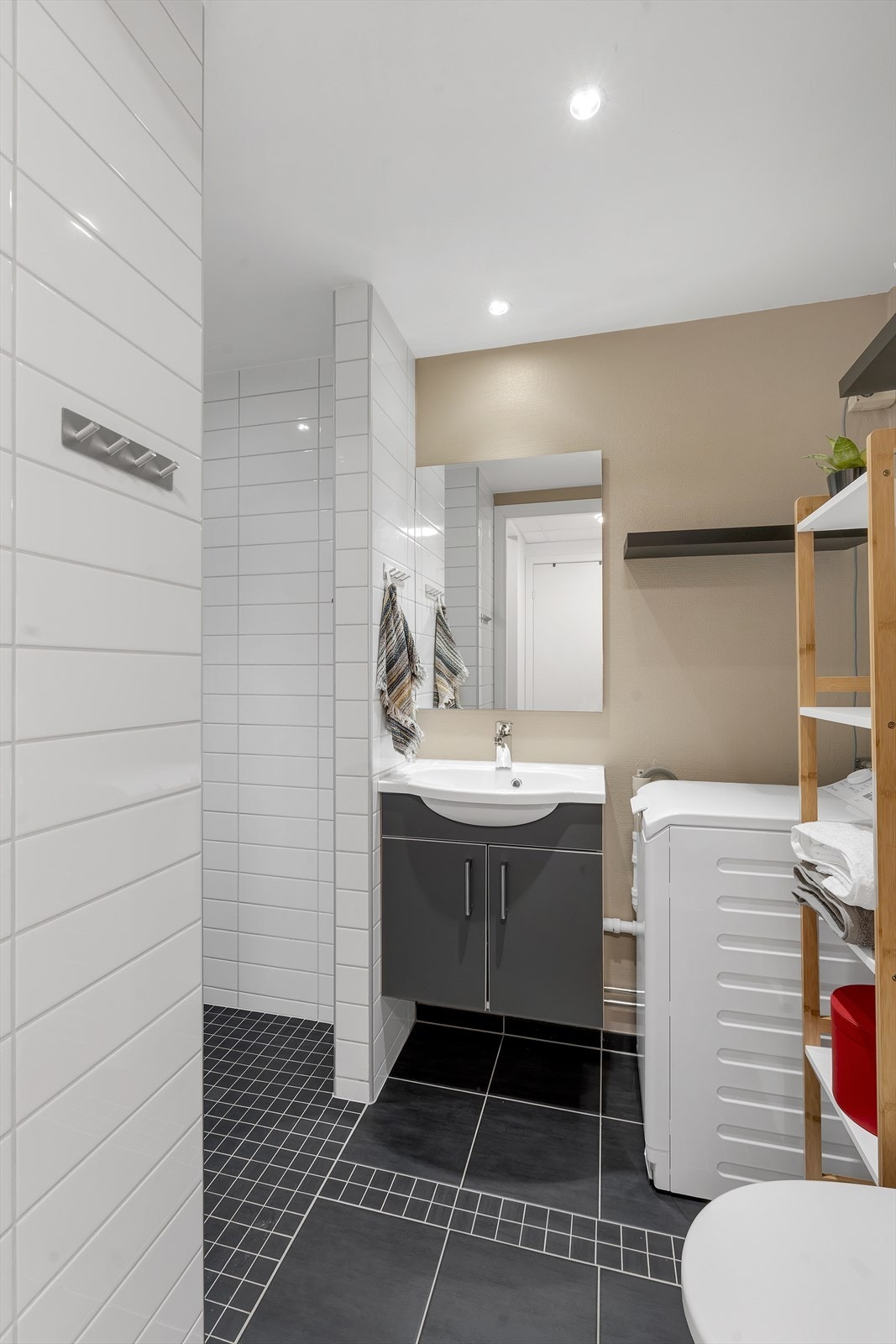 Flott bad, med praktiske innredninger, flisgulv med varme, og opplegg for vaskemaskin. Galleribilde