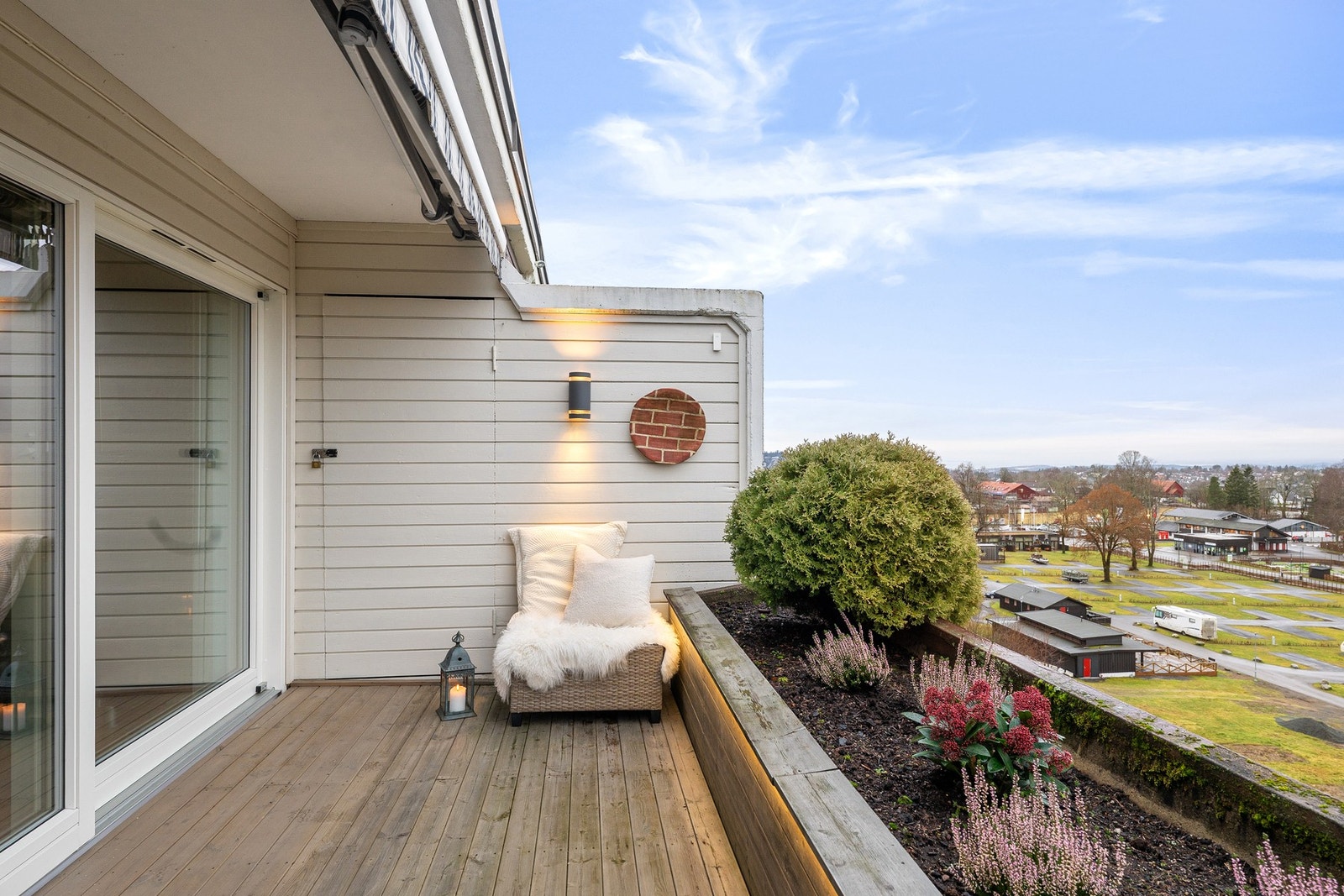 En lun og solrik terrasse med belysning som gir gode bruksforhold også etter solen har gått ned. Galleribilde