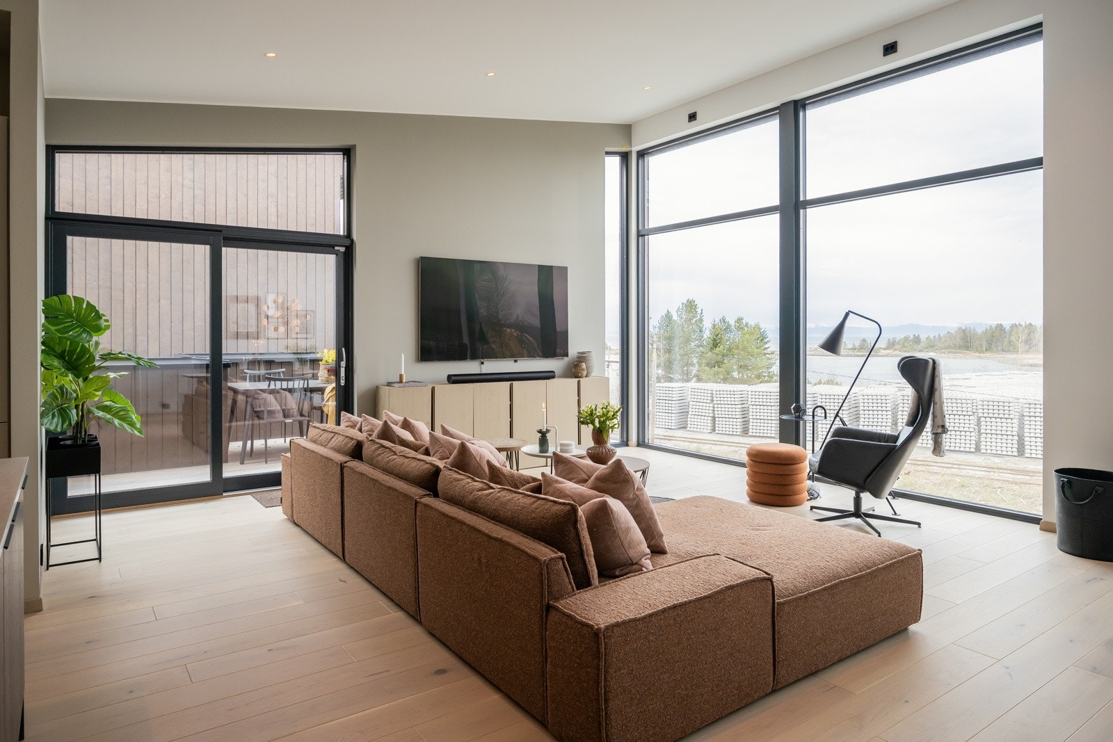 Lekkert og moderne uttrykk med store vindusflater, lsitefrie overganger, rikelig med innlys, og usjenert plassering med utsikt mot fjorden. Galleribilde