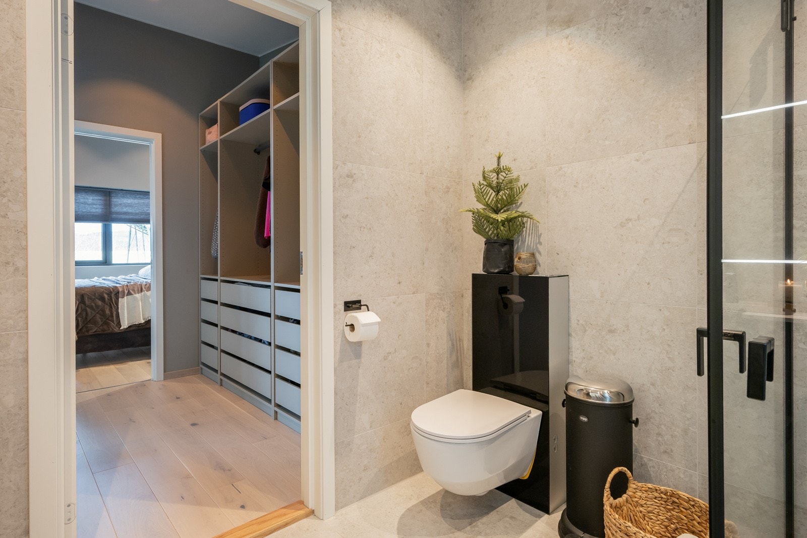 Badet er utstyrt med gulvvarme, vegghengt toalett, dusjhjørne med innfellbare dører, og servant over baderomsinnredning. Galleribilde