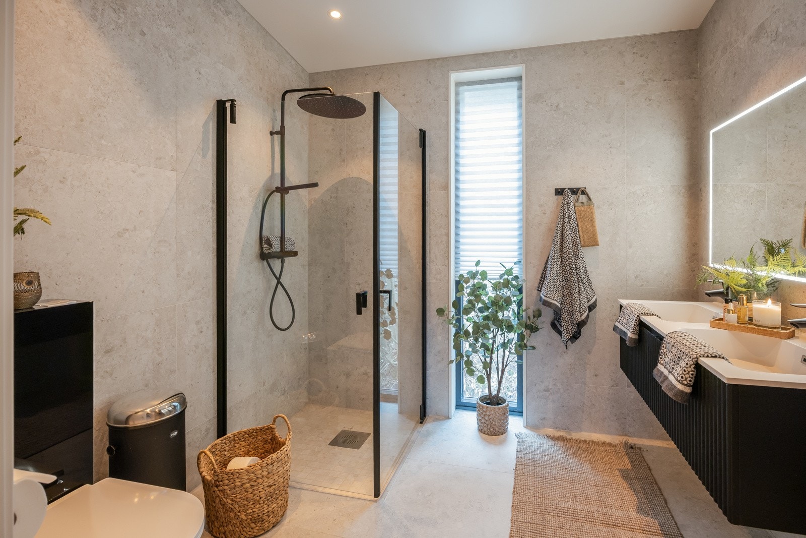 Lekre flisvalg og tidsriktig preg med sorte detaljer på innredning, dusjdører og armatur. Galleribilde