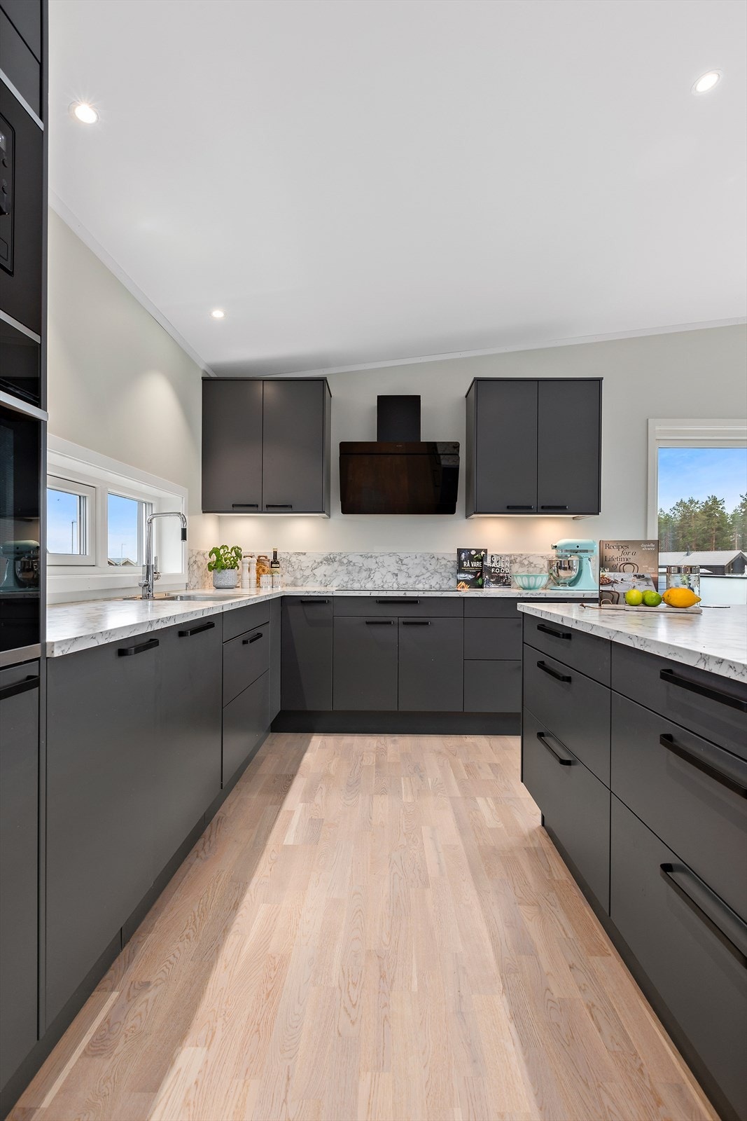 Det moderne kjøkkenet har rikelig med skapplass og benkeplass, noe som gir både praktisk oppbevaring og god arbeidsflate til matlaging. Galleribilde