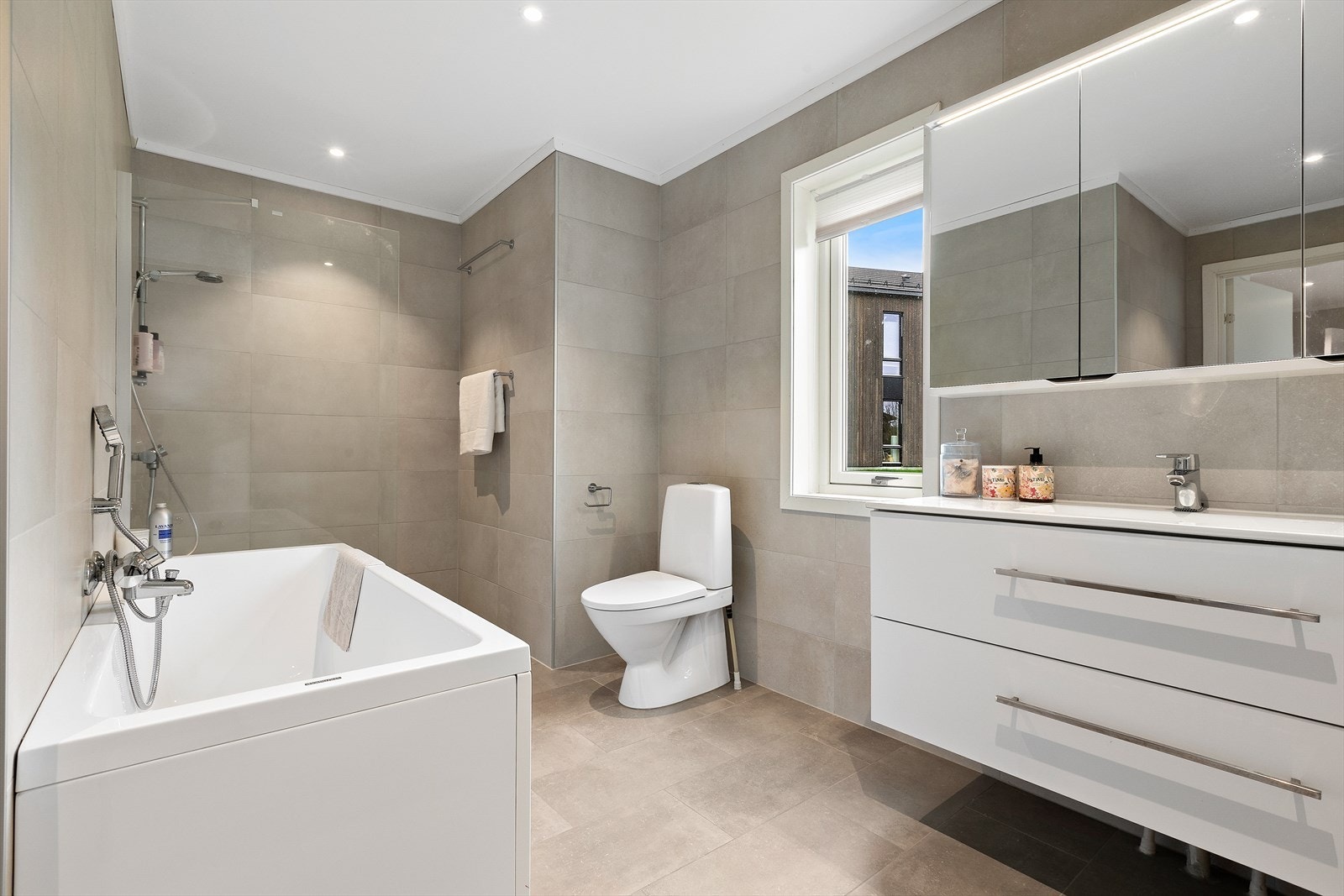 Tidsriktig innredet bad med moderne farge- og materialvalg. Badet er flislagt og har varmekabler i gulv og malt himling. Galleribilde