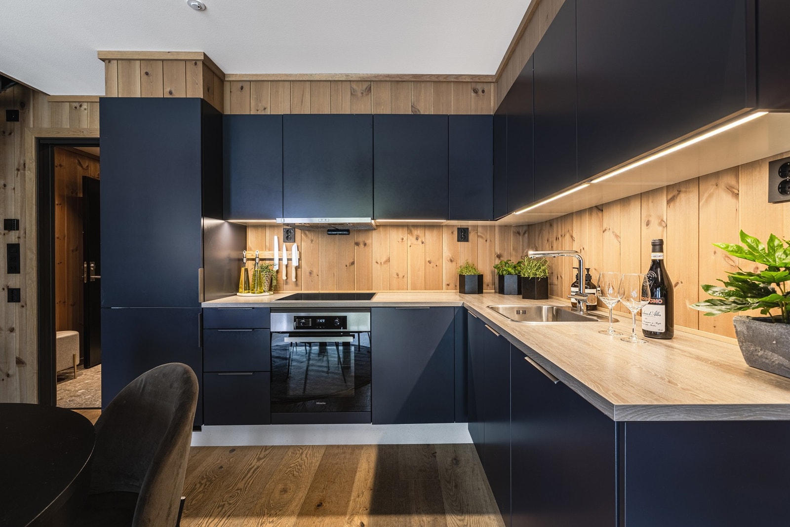 Kjøkken i tidsmessig mørk utførelse med integrerte hvitevarer. Galleribilde