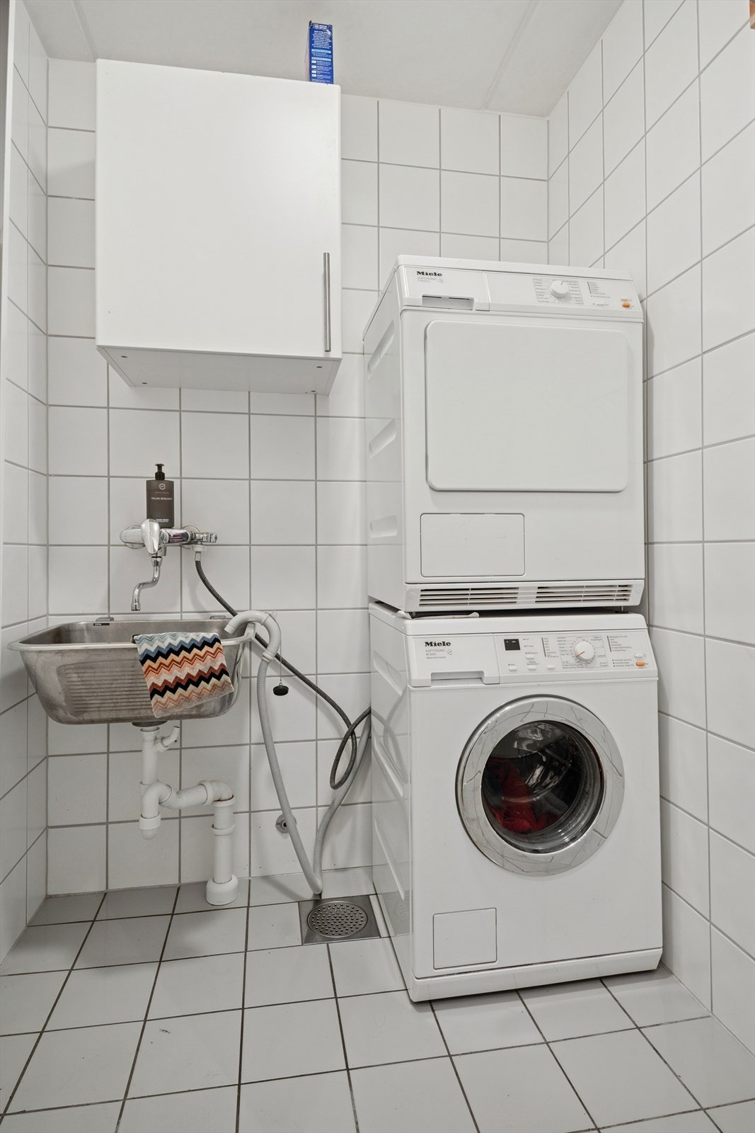 Praktisk separat flislagt vaskerom. Opplegg for vaskemaskin og tørketrommel. Utslagsvask og overskap. Galleribilde