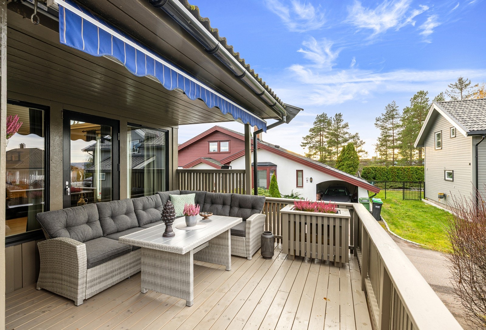 Hyggelig terrasse utenfor stuen med god plass til sittegruppe og beplantning, og det er utstyrt med markise som gir behagelig skygge på varme dager. Galleribilde