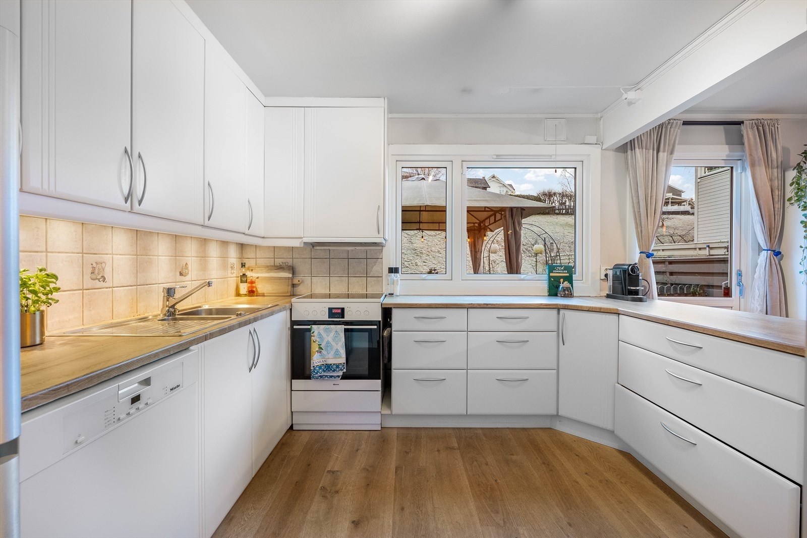 Lyst og funksjonelt kjøkken med tidløse materialvalg. Galleribilde