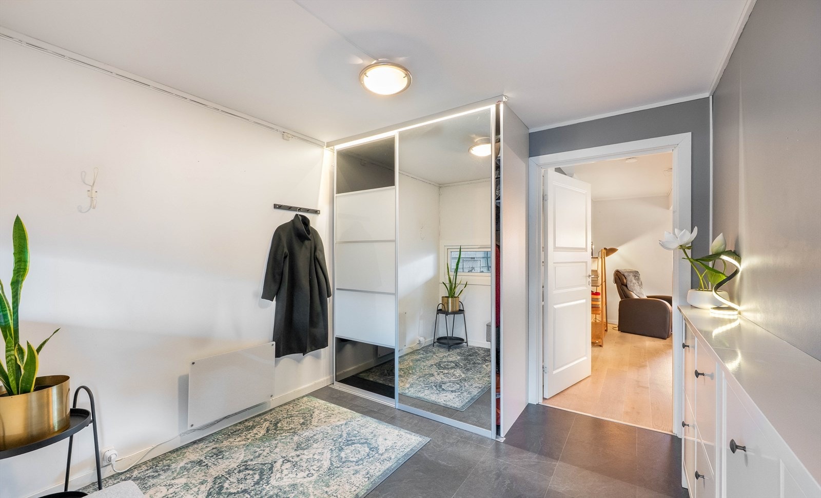 Innbydende entré med god garderobeplass og stilrent uttrykk. Her har du godt med oppbevaringsplass i skyvedørsgarderobe. Galleribilde