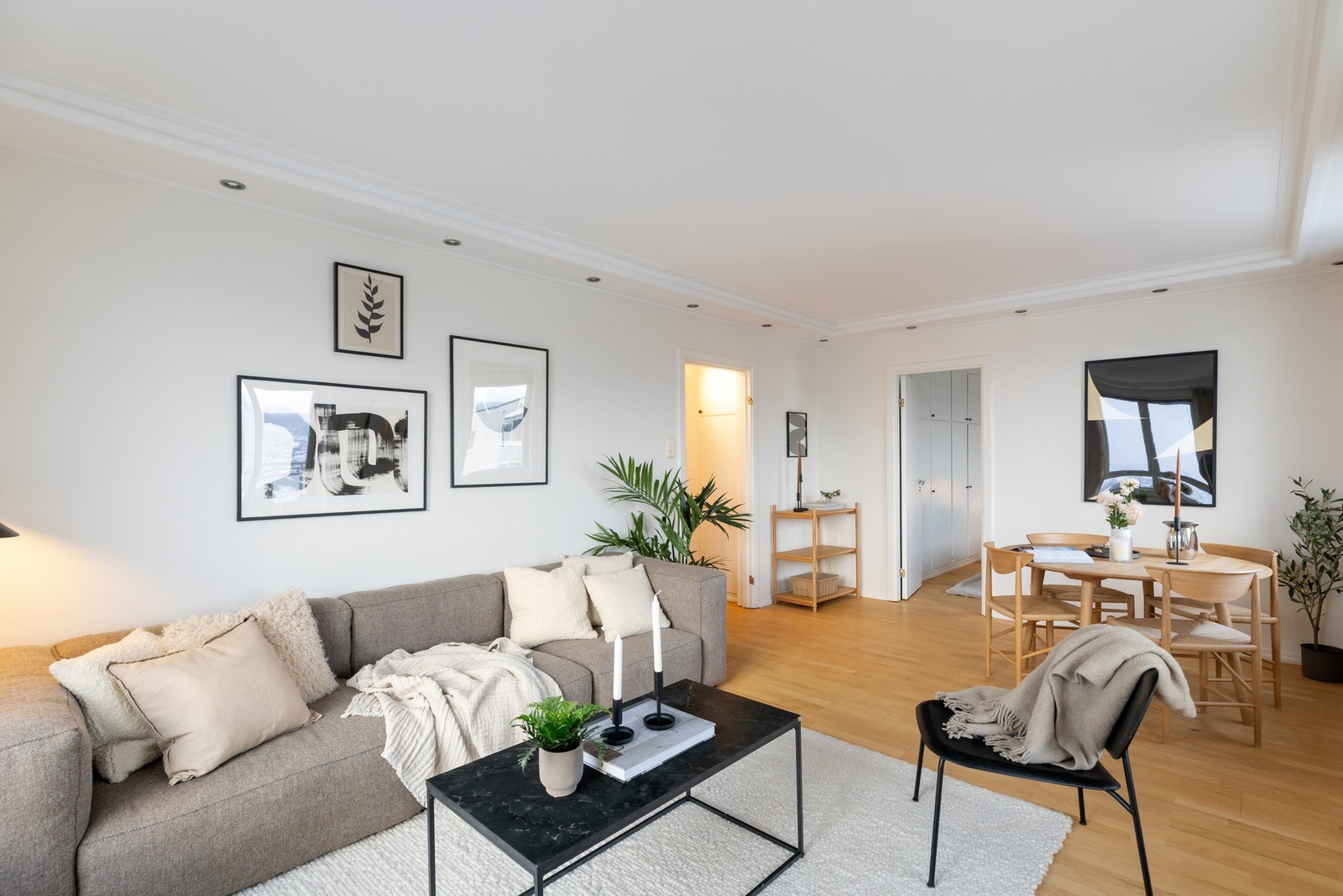 Lys og luftig stue med eikeparkett på gulv og malt strie på vegger. Downlights i himling langs vegger gir behagelig belysning. Galleribilde