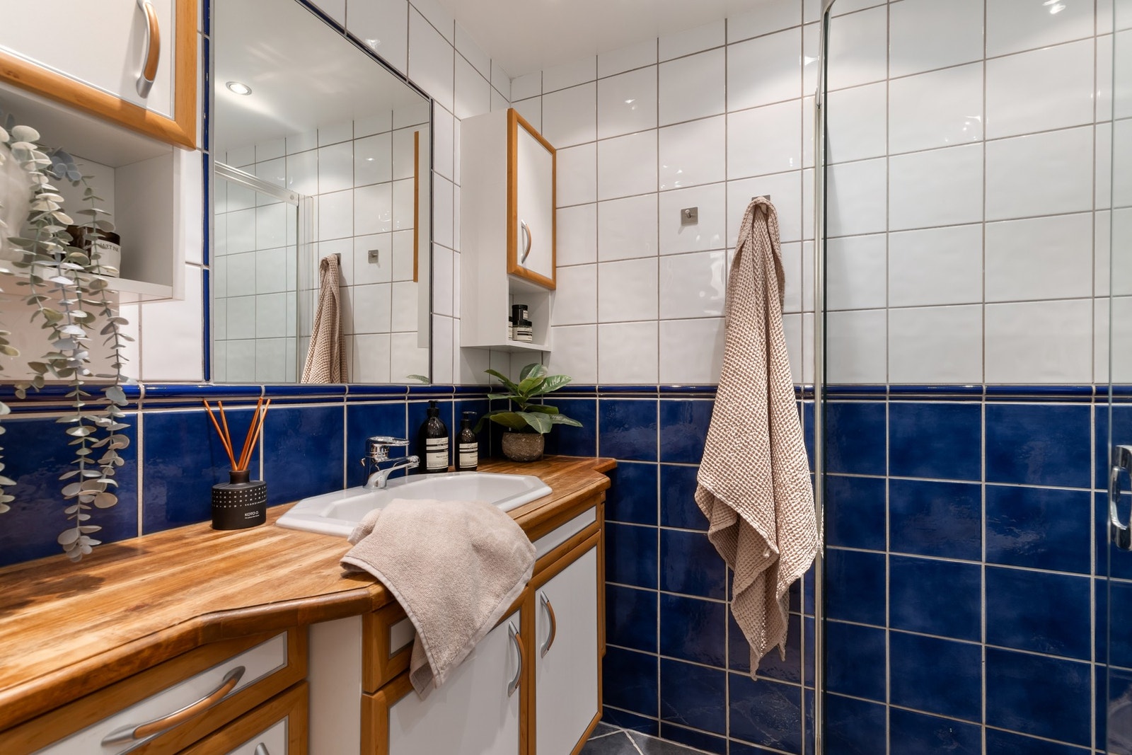 Flislagt bad fra sent 1990-/tidlig 2000-tall med varmekabler i gulv og downlights i himling. Galleribilde