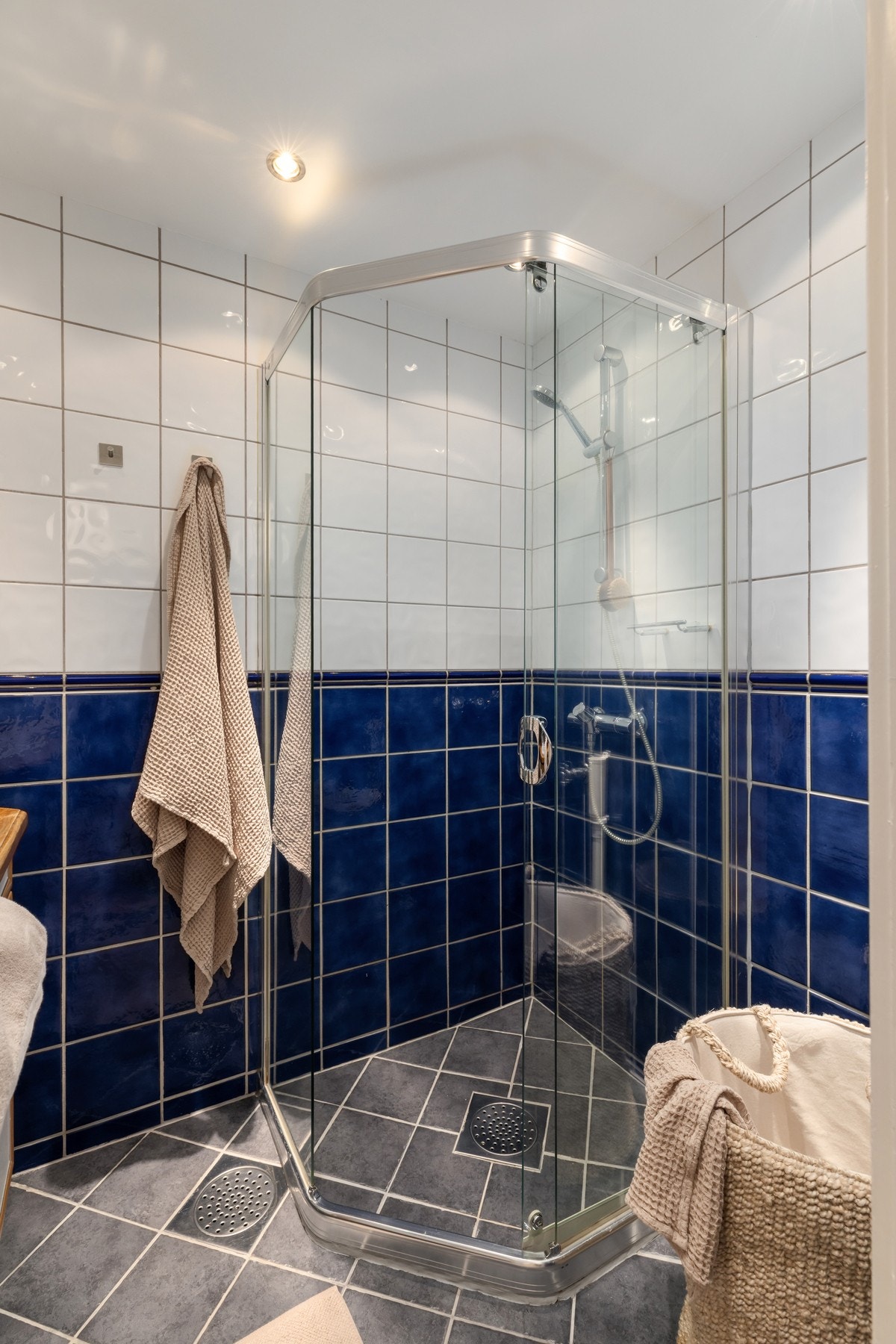 Badet inneholder servant med underskap, innfliset speil installert varmekabler , veggskap og lukket dusjhjørne med skyvedør. Galleribilde