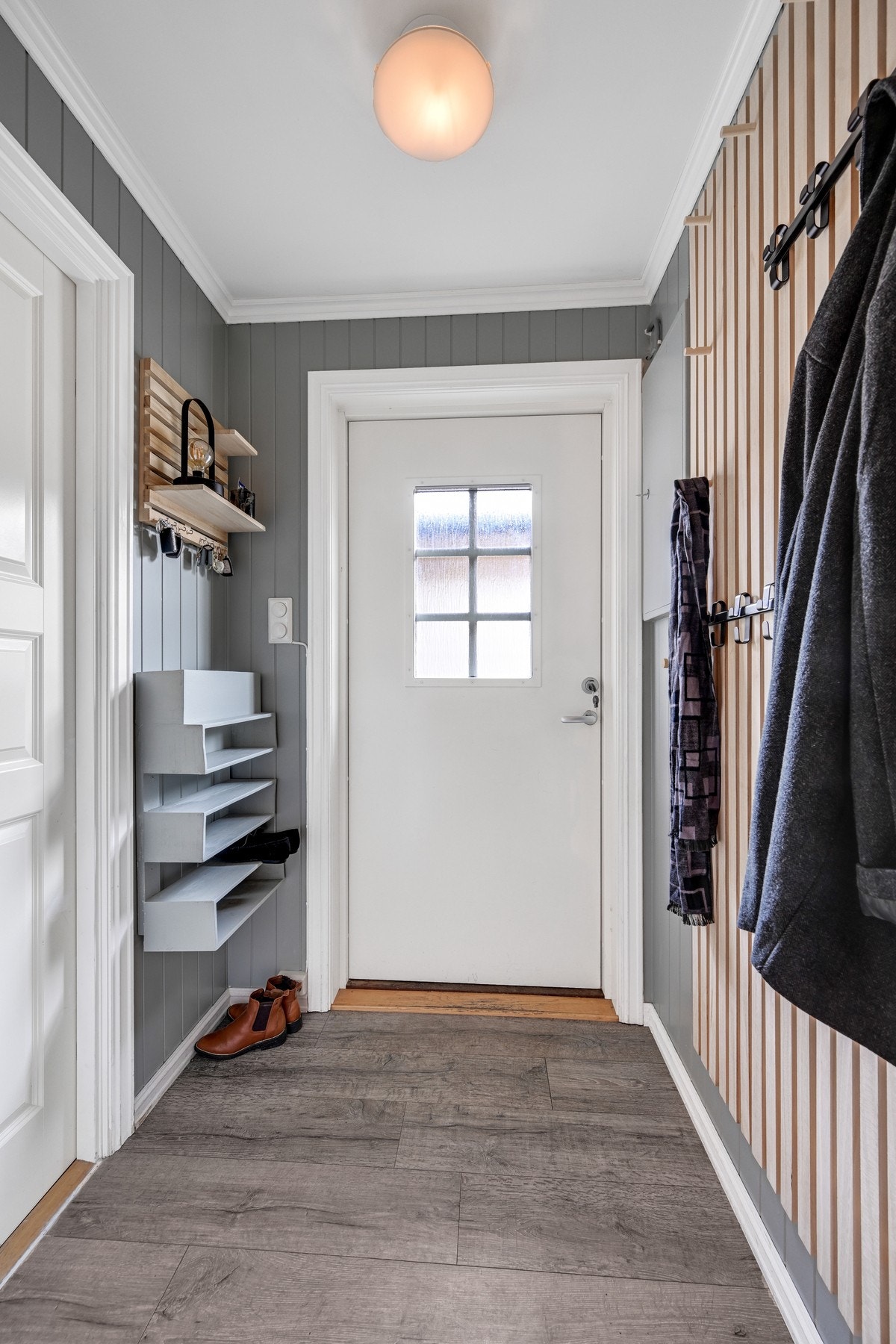Velkommen inn i en innbydende entré med stilige spiledetaljer på veggene og et gulv av laminat Galleribilde