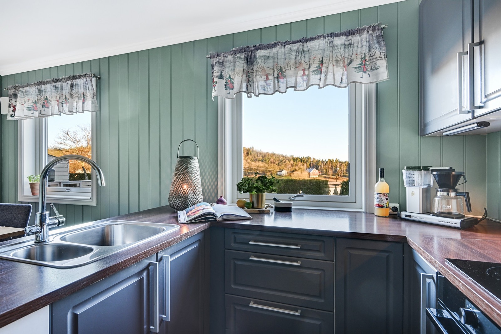 Det er benkeplate av laminat, og integrert komfyr m/koketopp og kjøleskap. Galleribilde