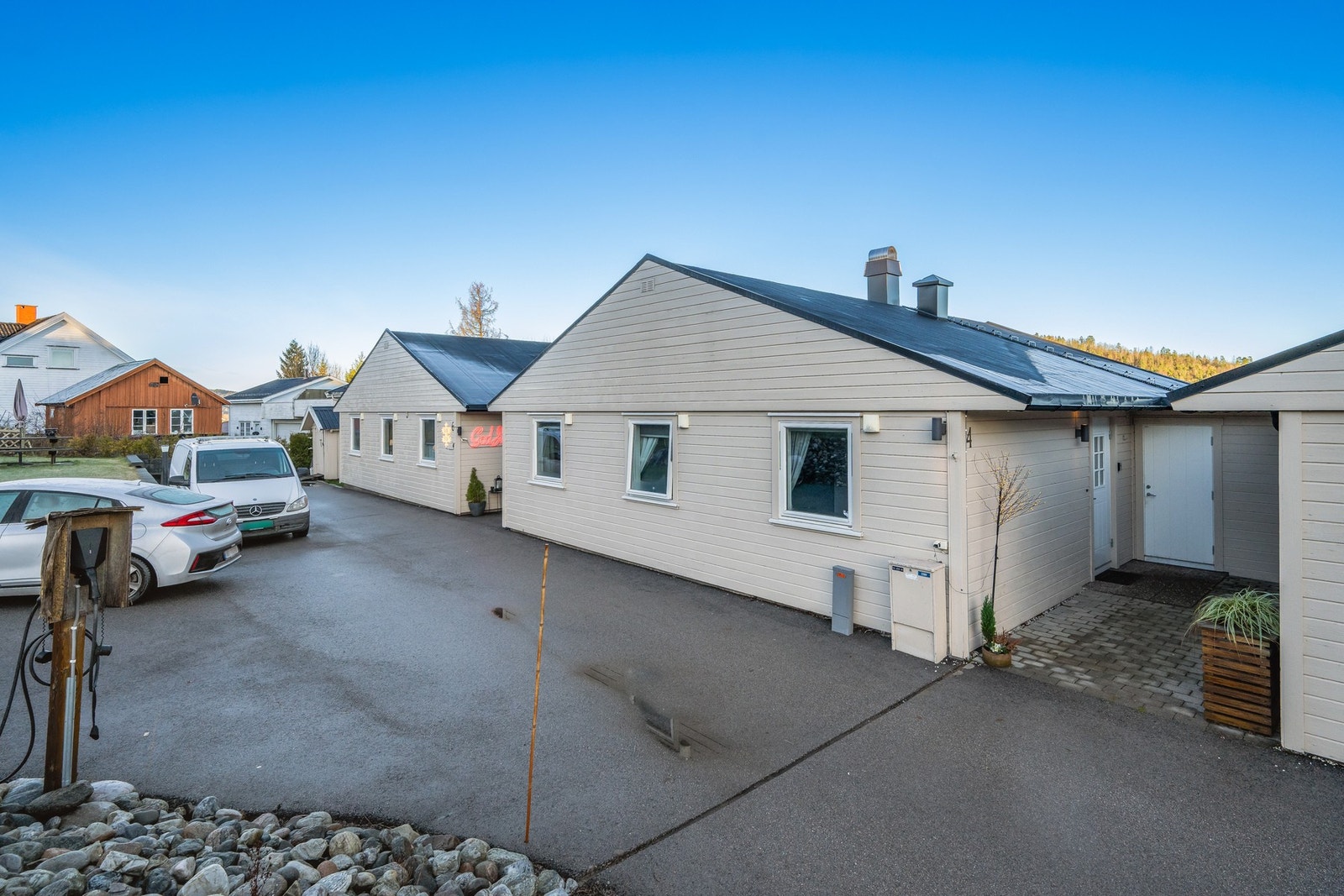 Like ved inngangspartiet er det 2 parkeringsplasser og elbillader. I tillegg har man en garasjeplass i rekke Galleribilde