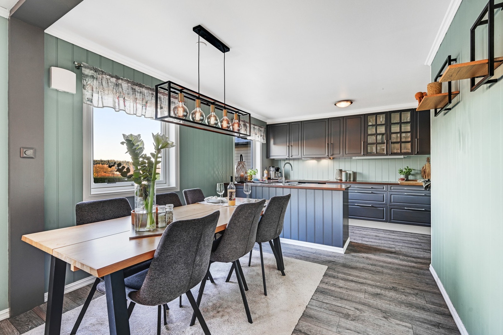 Øyløsningen sørger for et skille mellom kjøkken og stue, hvor maten praktisk kan serveres Galleribilde