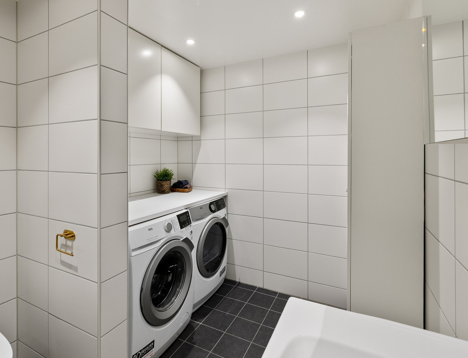 God plass på badet med egen seksjon for vask og tørk, komplettert med skap og lagringsmuligheter Galleribilde