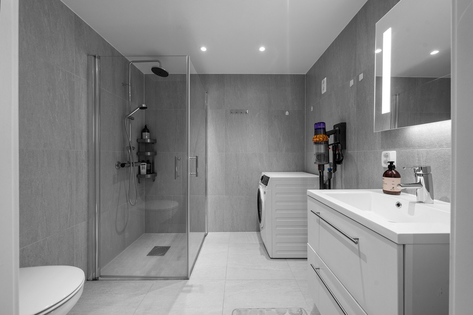 Badet er delikat med store, moderne fliser, downlights og varme på gulvet Galleribilde