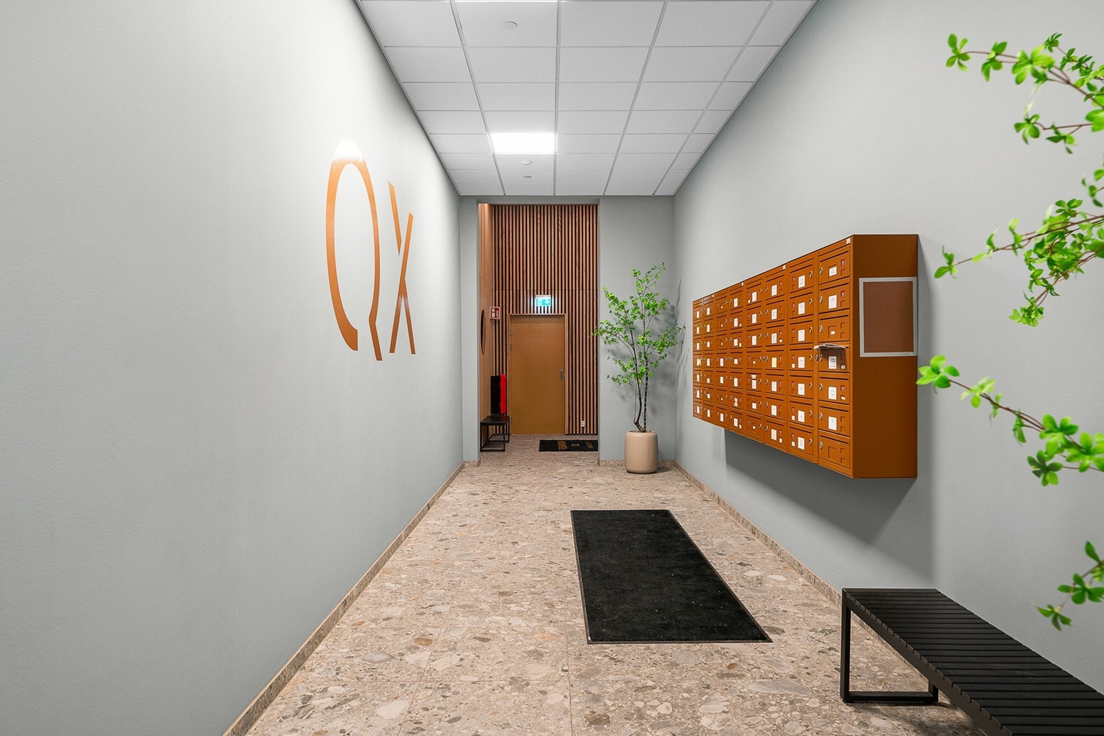 Flott hall med postkasser og sittebenk i inngangspartiet Galleribilde