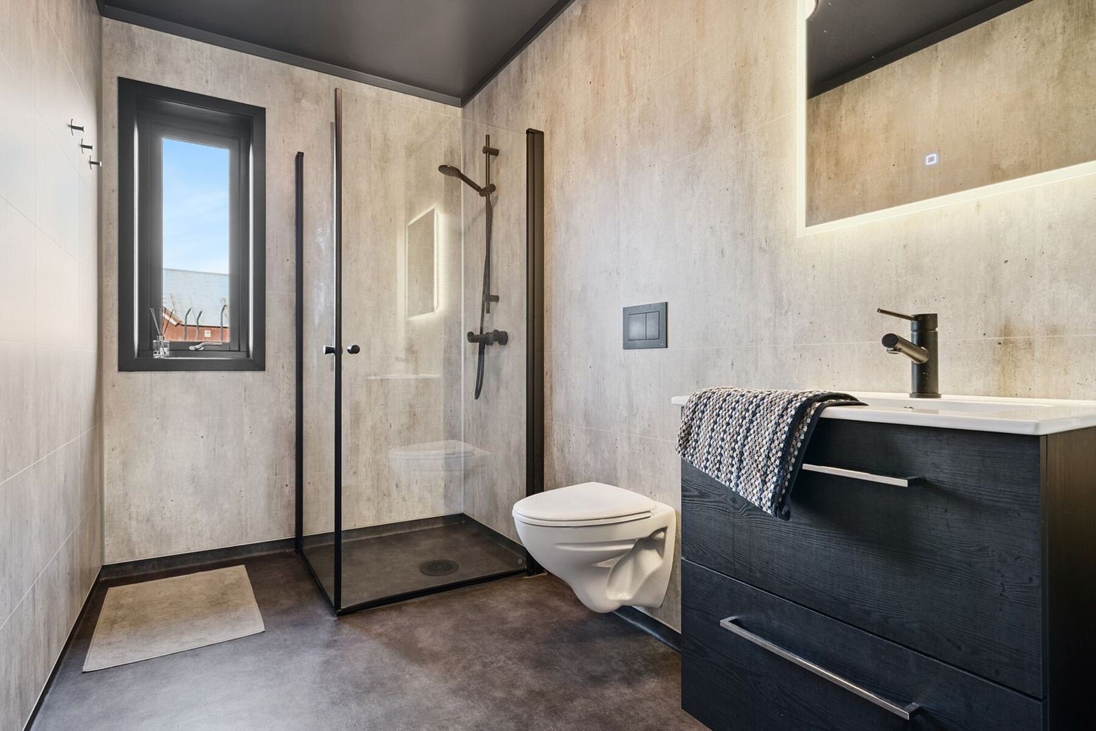 Bad i tilknytning til entre. Utstyrt med servant, speil, vegghengt toalett og dusjhjørne med innfellbare glassdører. Galleribilde