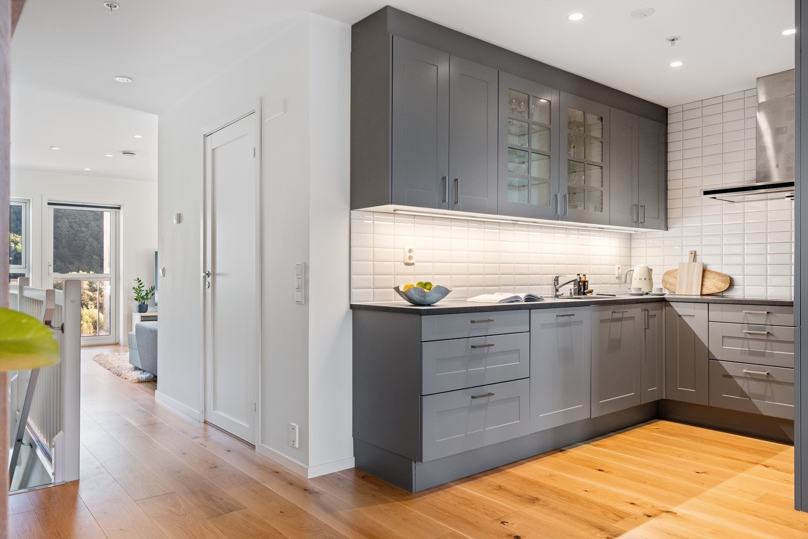 Lekkert HTH kjøkken med slette fronter, laminat benkeplate og fliser over benkeplate. Galleribilde