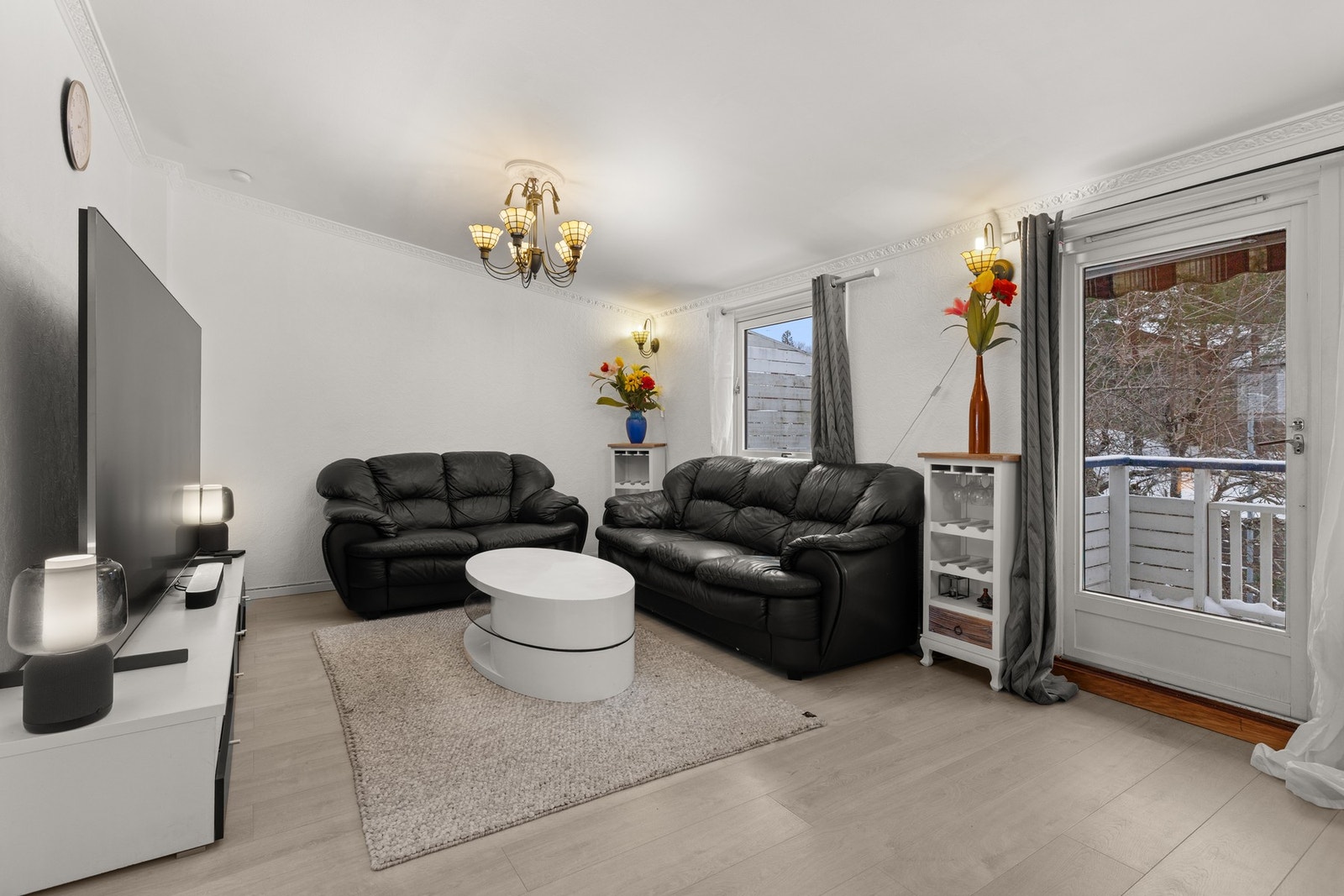 Store vindusflater gir rikelig med dagslys, og rommet oppleves lyst og luftig. Galleribilde