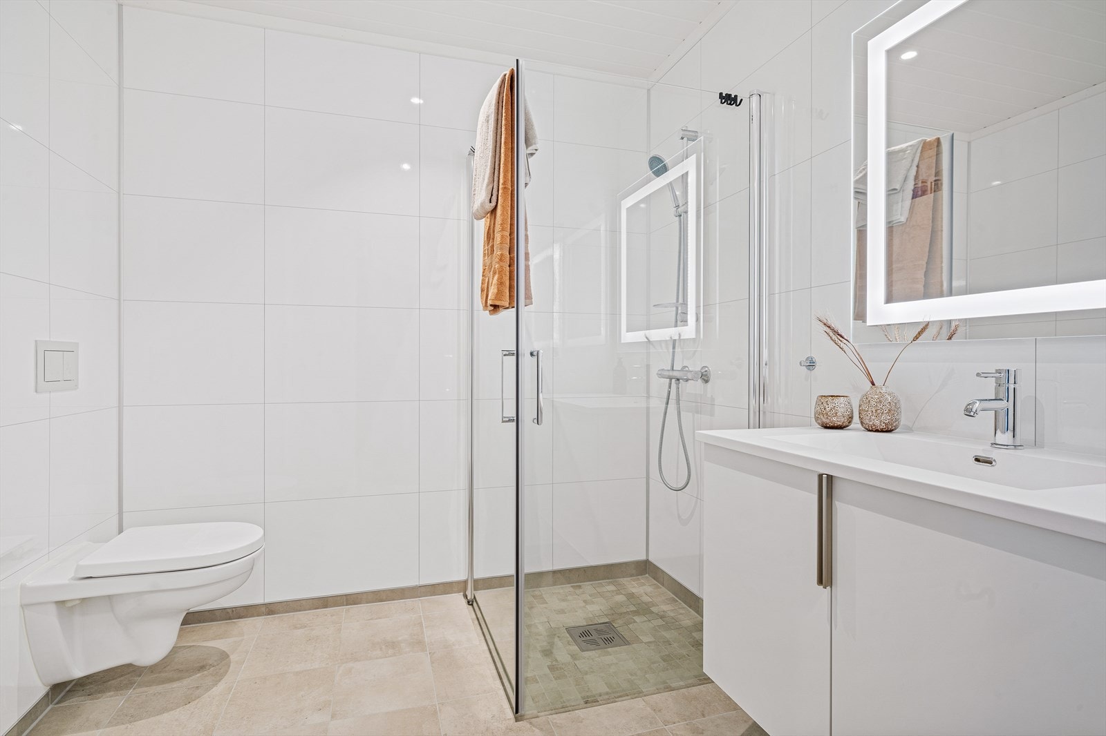 Badet i 1.etasje har samme dusjvegger, baderomsinnredning, høyskap, vegghengt toalett som i 2.etasje. I tillegg er det satt opp eget opplegg for vaskesøyle/vaskemaskin. Galleribilde