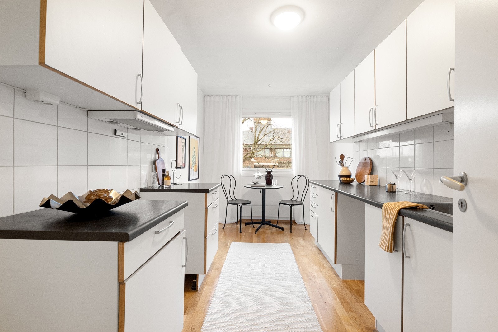 Lyst kjøkken i eget rom, med profilerte fronter og laminert benkeplate. Galleribilde