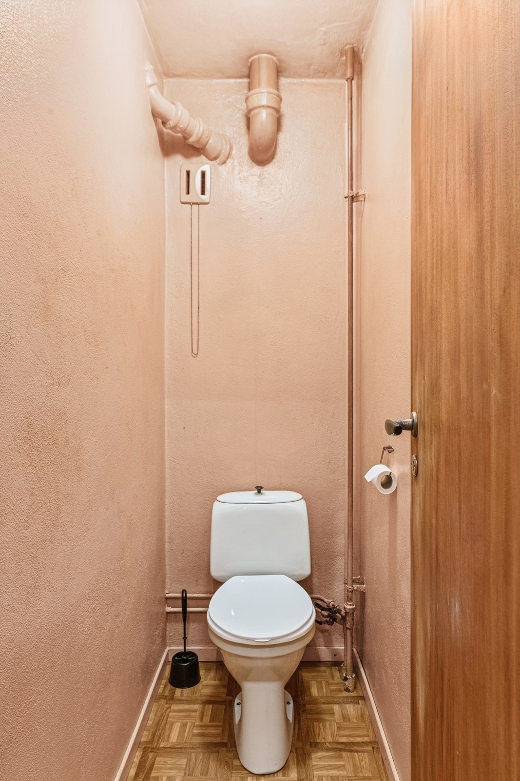 Toalettrommet har belegg på gulvet og malte betongvegger, og er innredet med et gulvmontert toalett. Galleribilde