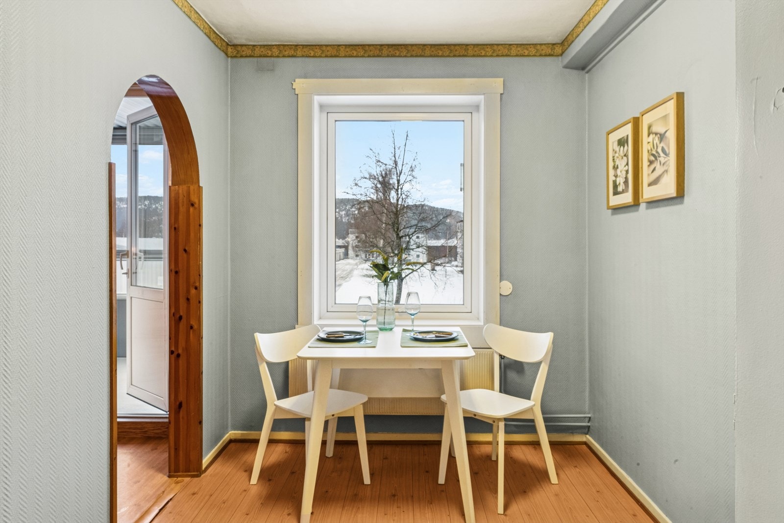 Delvis adskilt kjøkkenløsning med plass til frokostbord ved vindu. Galleribilde