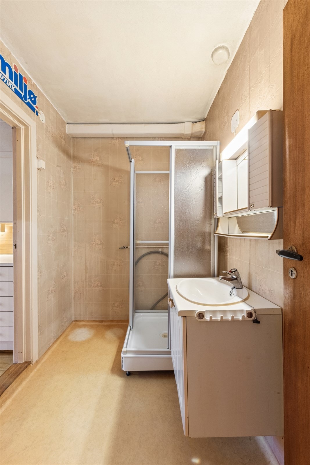 Eldre baderom med belegg på gulvet og våtromstapet på veggene. Galleribilde