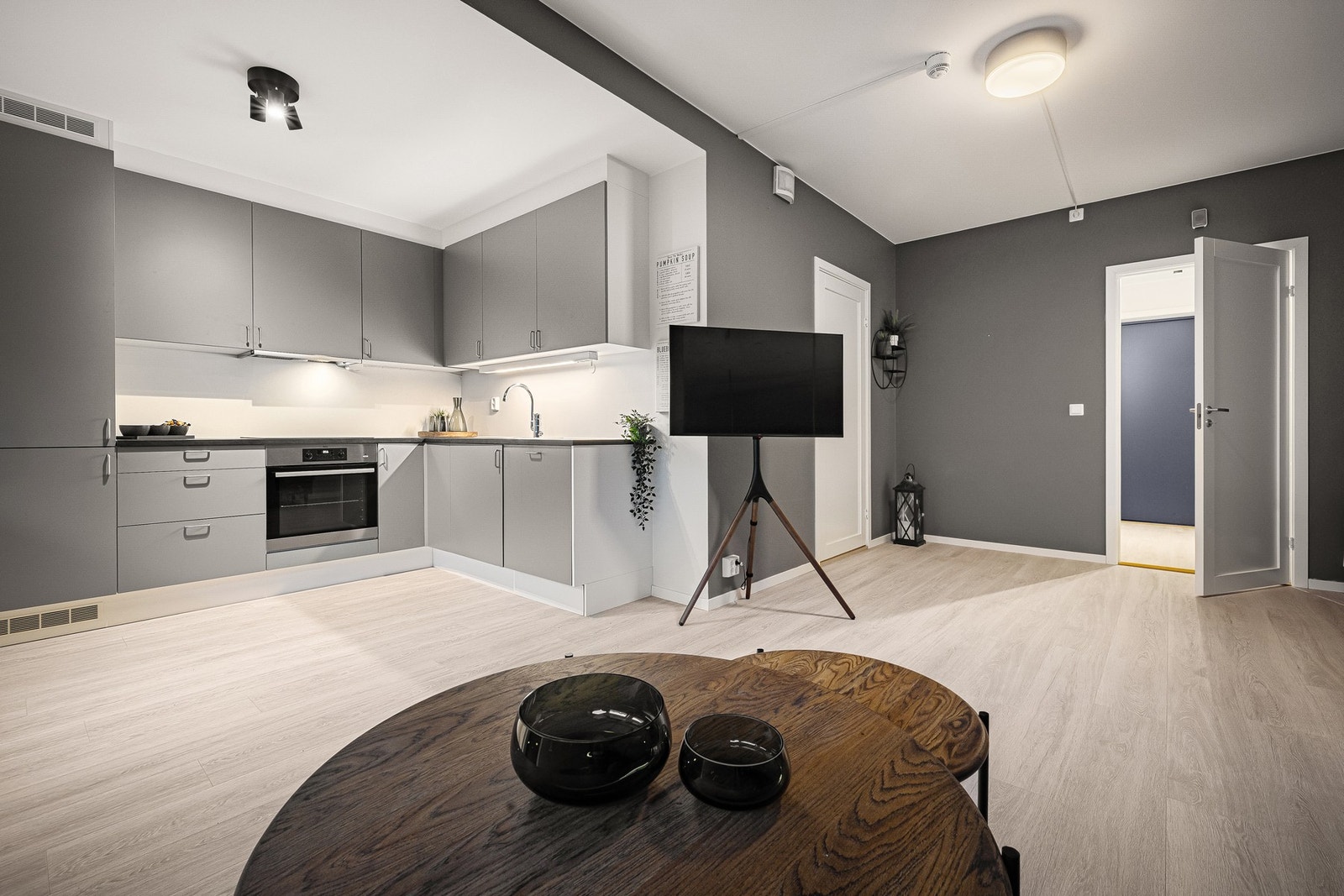 Kjøkkenet har kjøkkeninnredning fra HTH med slette grå fronter og mørk laminat benkeplate. Galleribilde