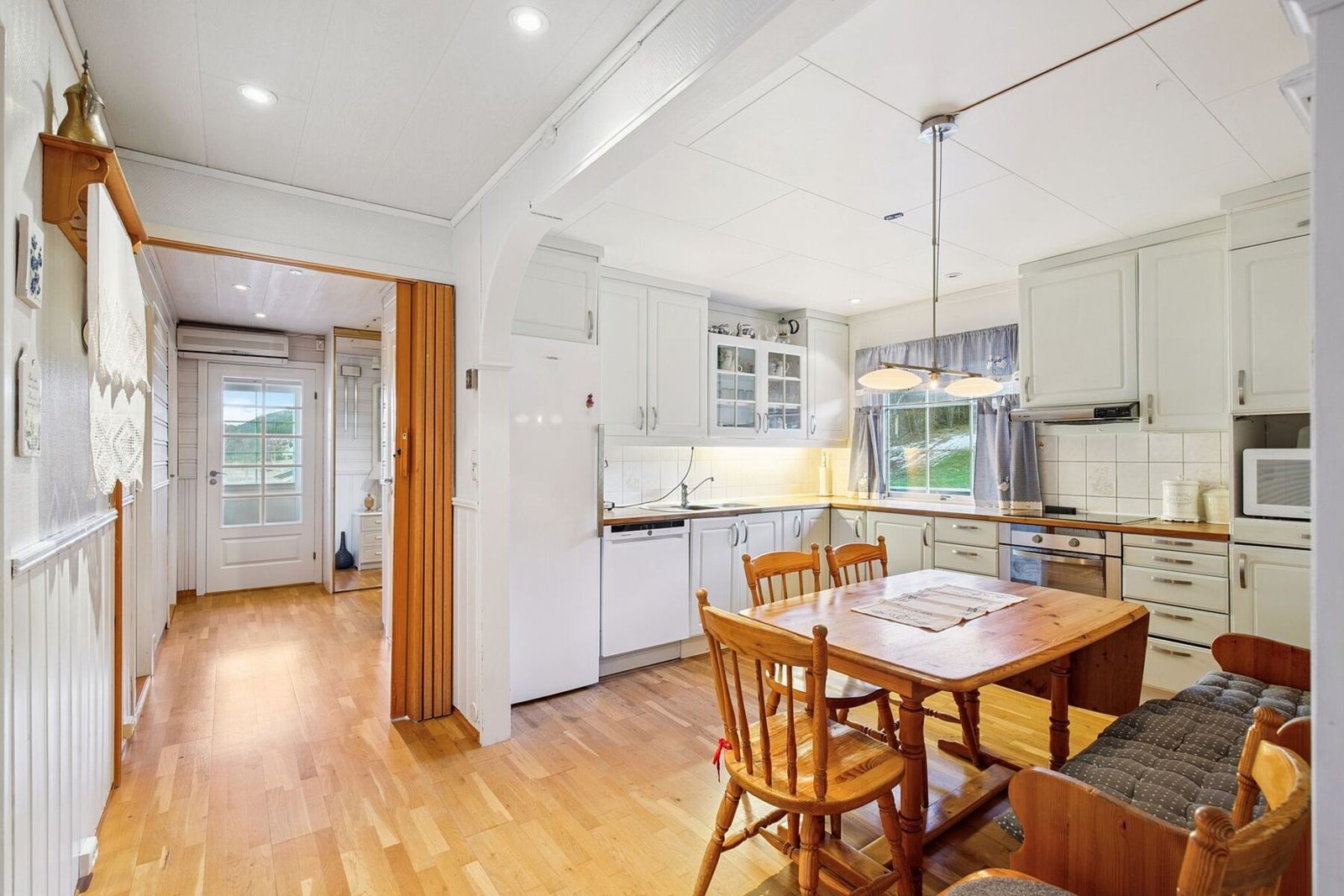 Lyst kjøkken som måler 11 kvadratmeter med rikelig med oppbevaringsplass. Galleribilde