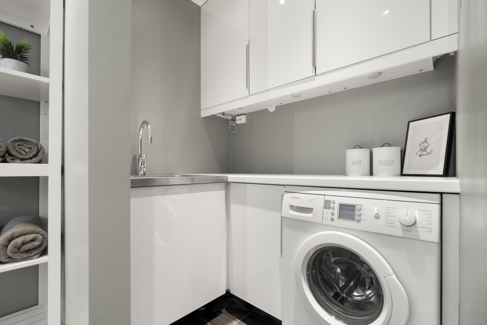 Det er eigen vaskeromsavdeling på badet med skapinnredning, benk og utslagsvask Galleribilde