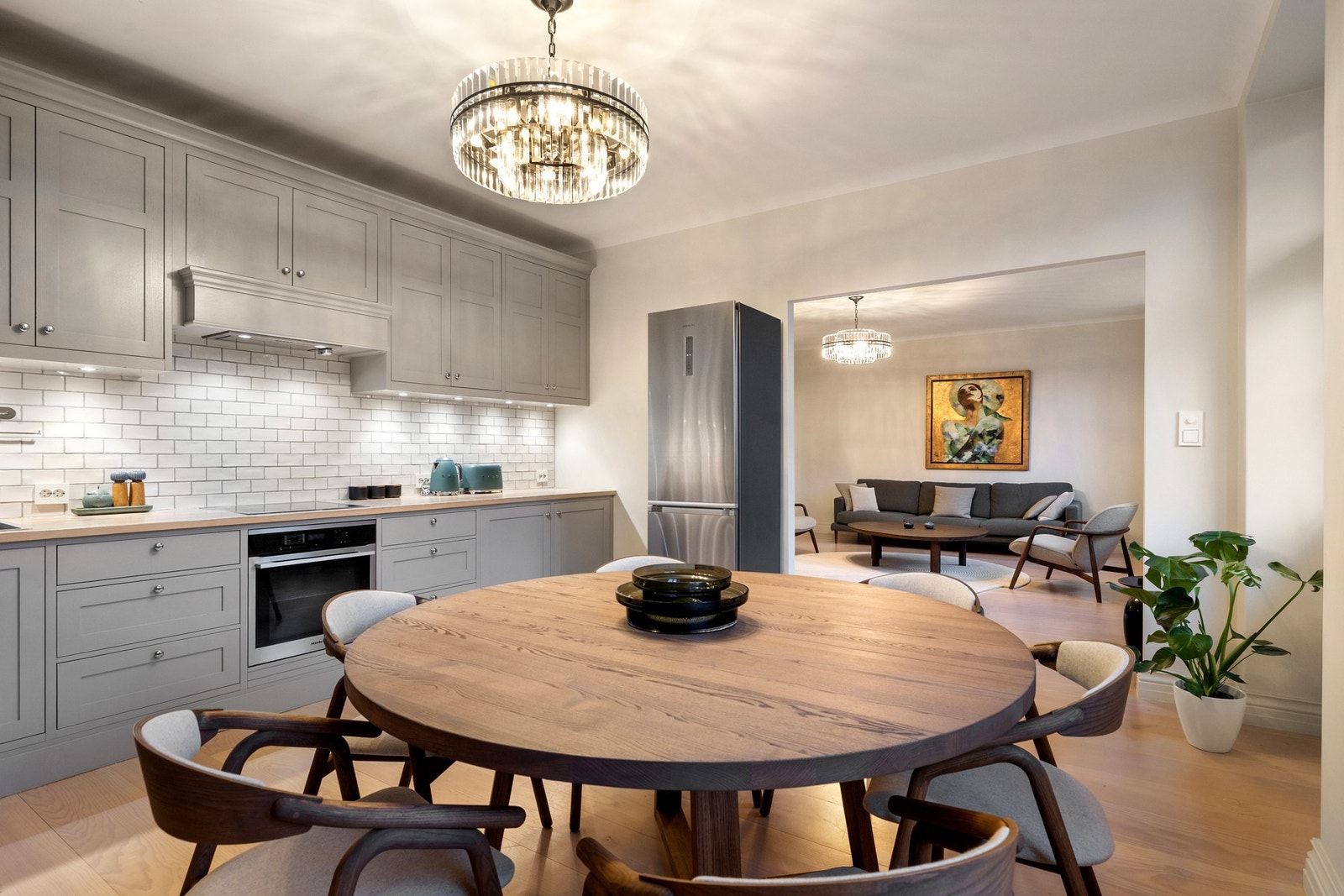 Kjøkkeninnredningen er levert av møbelsnekker og har grå profilerte fronter med knotter i børstet stål, noe som gir et tidløst og klassisk uttrykk. Galleribilde