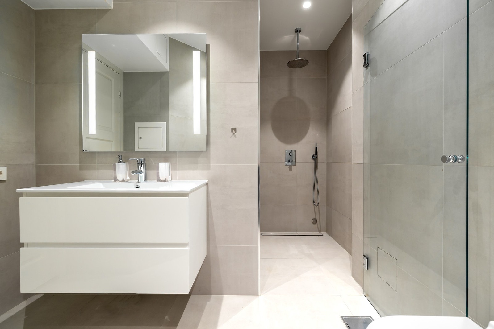 Baderomsinnredningen består av en servant med praktiske skuffeløsninger som gir god oppbevaringsplass. Over servanten er det montert speil med integrert belysning. Galleribilde