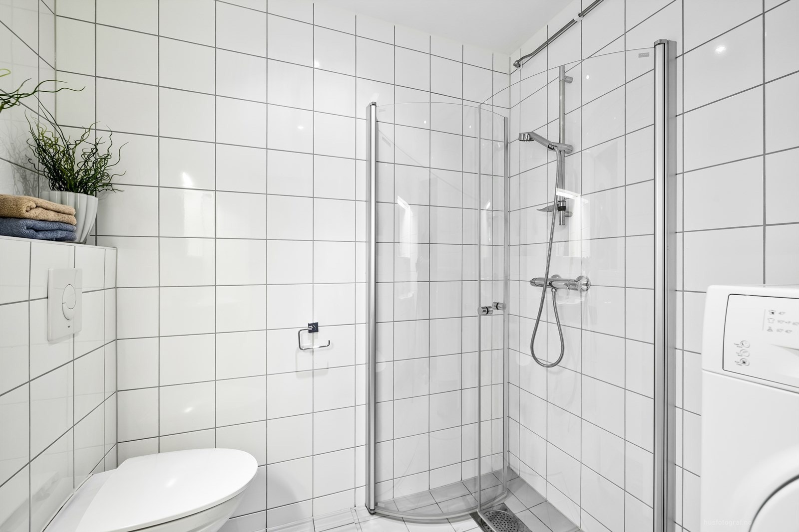 Badet er innredet med servant, toalett, dusjhjørne og har opplegg for vaskemaskin og tørketrommel. Galleribilde