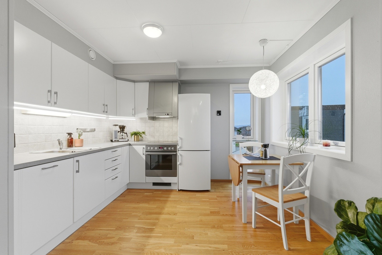 Lyst og flott kjøkken med integrert oppvaskmaskin, platetopp og komfyr Galleribilde