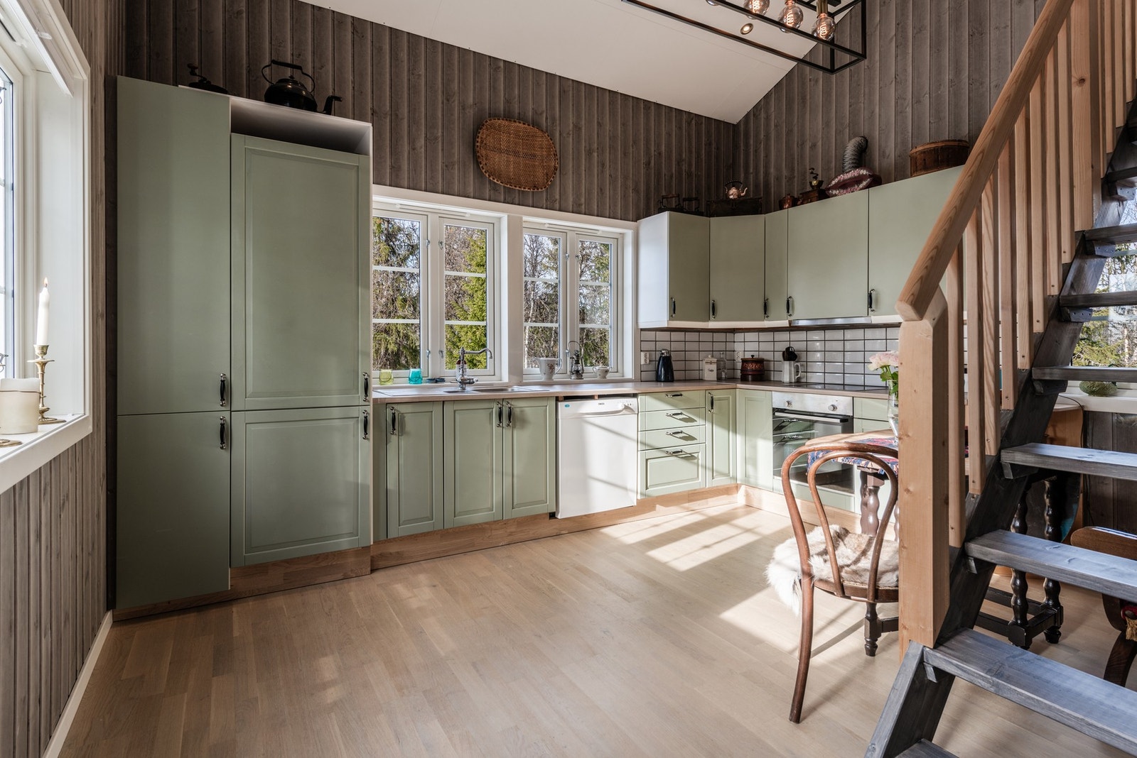 Romslig kjøkken med innredning i en nydelig grønnfarge og heltre benkeplate. Galleribilde