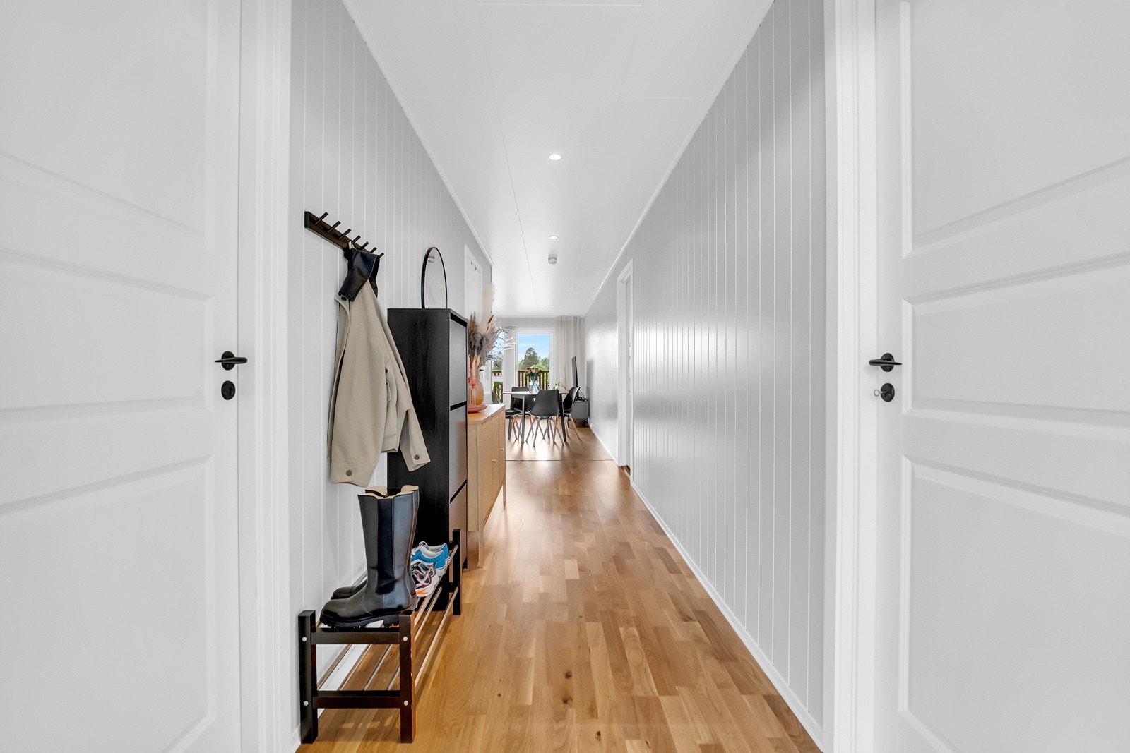 Velkommen inn! Gangen gir et ryddig og imøtekommende førsteinntrykk med plass til både yttertøy og sko. Herfra får du enkel tilgang til leilighetens øvrige rom. Galleribilde