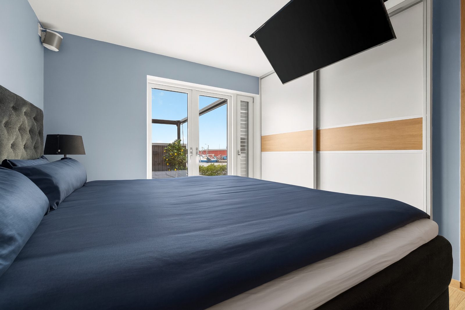 Lekkert hovedsoverom med god plass til oppbevaring og direkte utgang til terrasse - et rom som kombinerer komfort og privatliv. (Nedfellbar tv i taket) Galleribilde