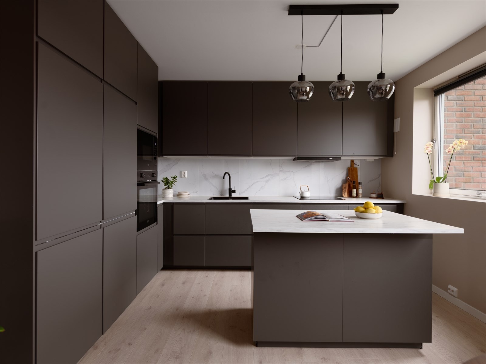 Den flyttbare kjøkkenøya lar deg endre uttrykket og funksjonen i rommet når du vil. Komfyr med induksjons platetopp, mikrobølgeovn, oppvaskmaskin og kjøl/frys er integrert i innredningen. Galleribilde