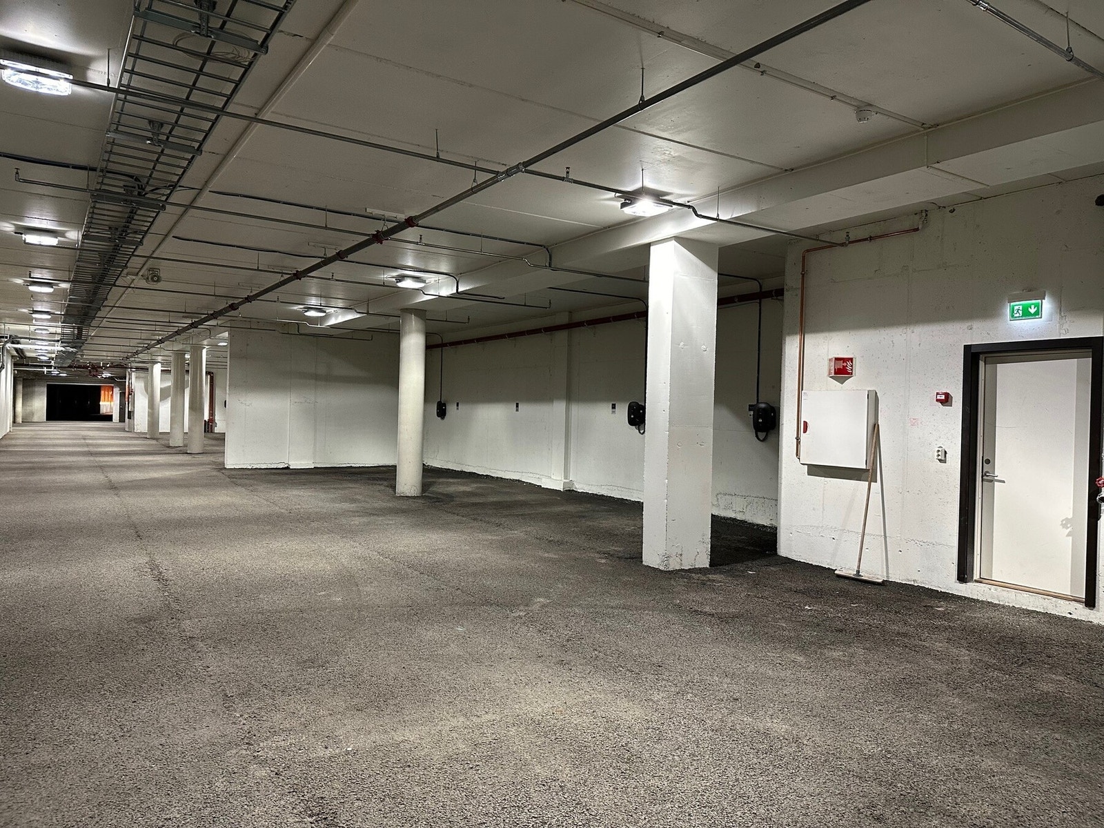 Parkeringsplass i felles parkeringsanlegg med el-bil lader. Galleribilde