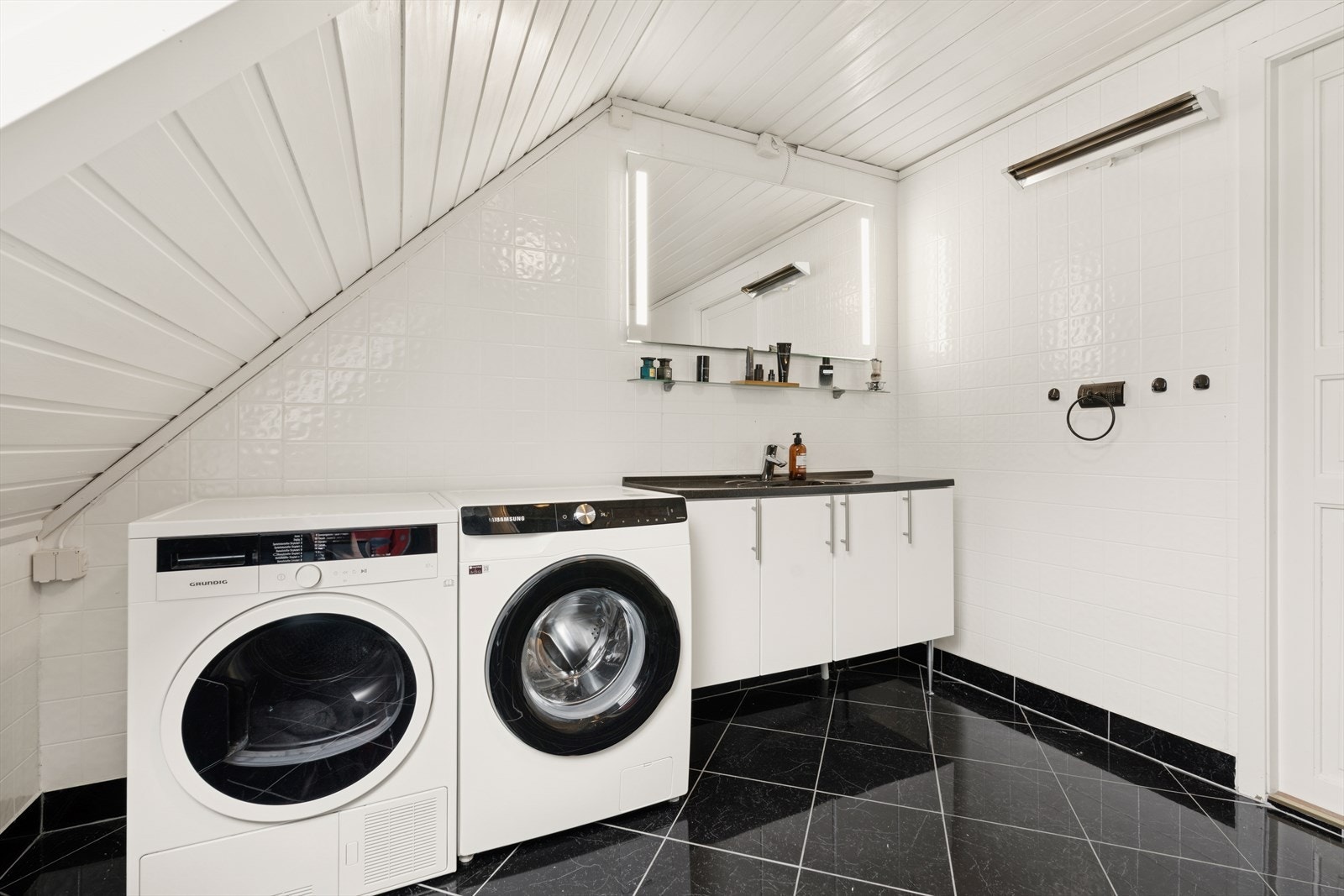 Rommet har dusj, toalett, seksjon med servant og opplegg for vaskemaskin. Galleribilde