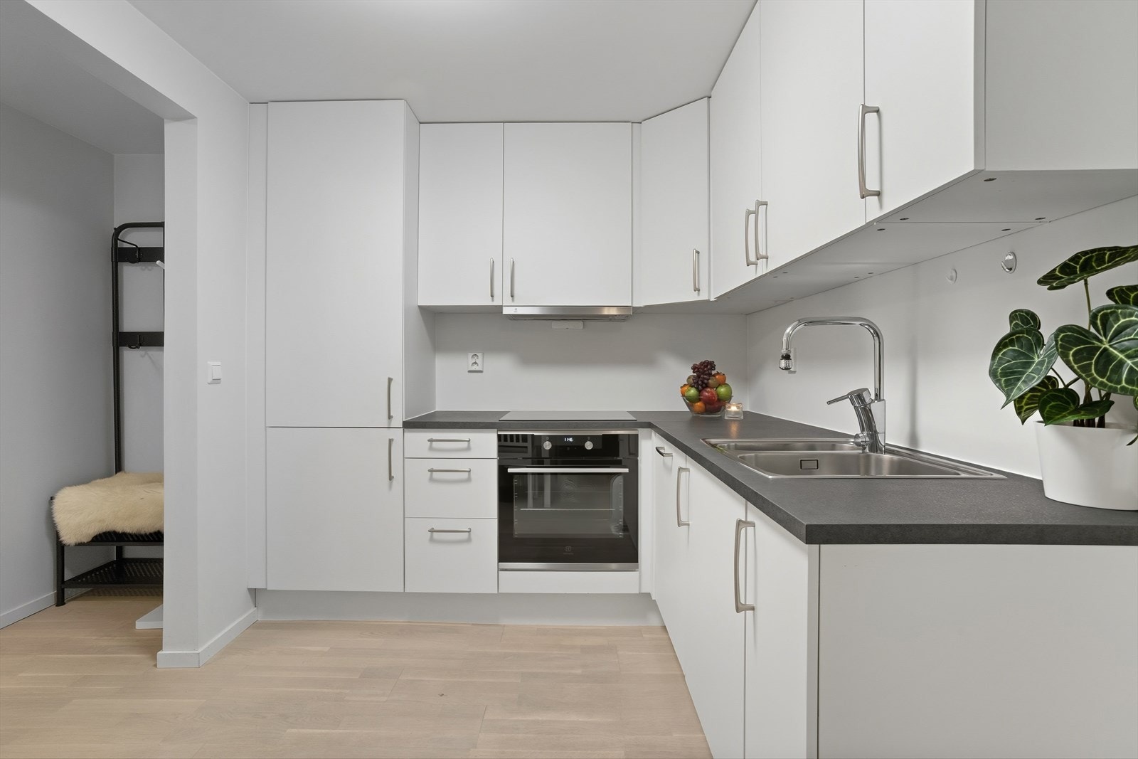 Kjøkkenet har innredning med glatte fronter og benkeplate av laminat Galleribilde