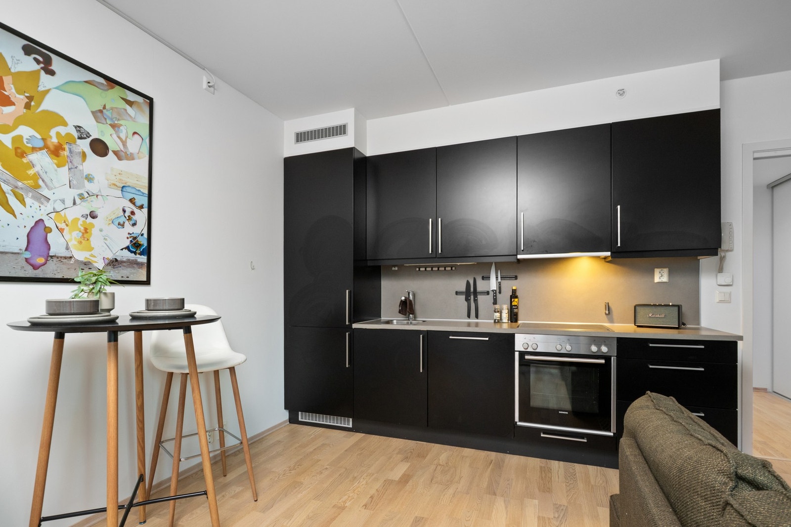 Innredningen har mørke, glatte fronter, praktisk laminatbenkeplate og enkel oppvaskkum Galleribilde