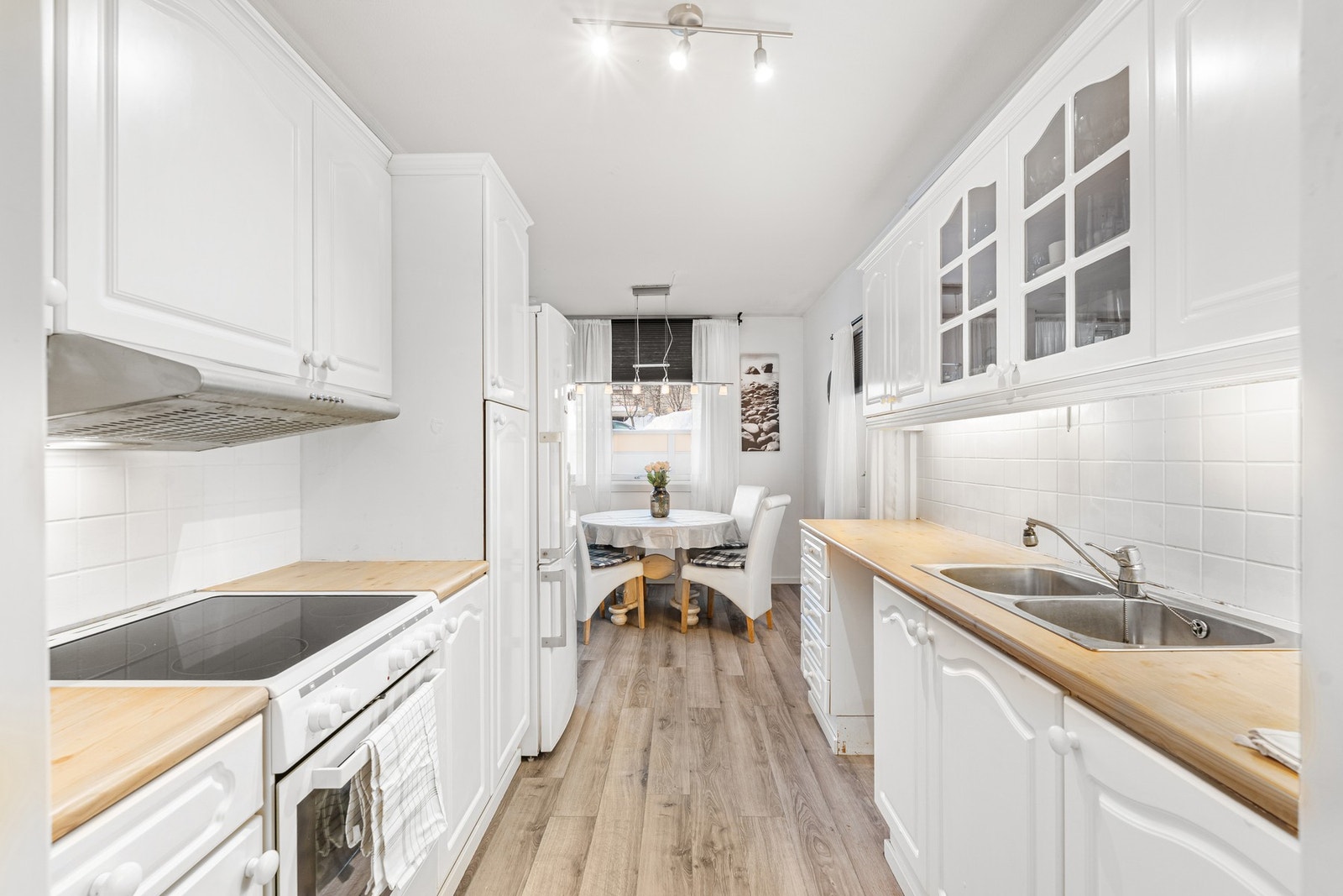 Kjøkkenet kombinerer klassisk design med lyse flater og flis på vegger for en lun og behagelig atmosfære. Galleribilde